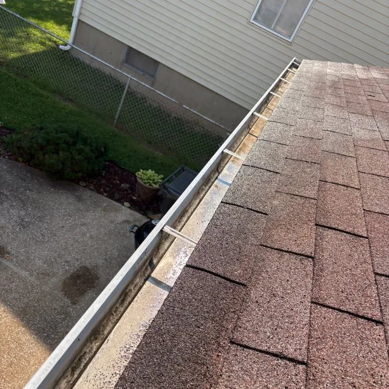 Gutter section holding standing water and grit before clearing, O'Fallon