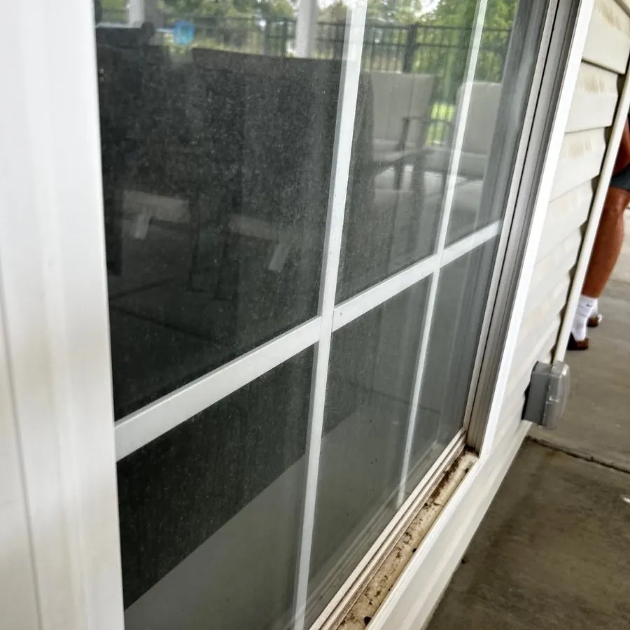 Patio sliding door with dusty glass and a dirty sill before cleaning, O'Fallon